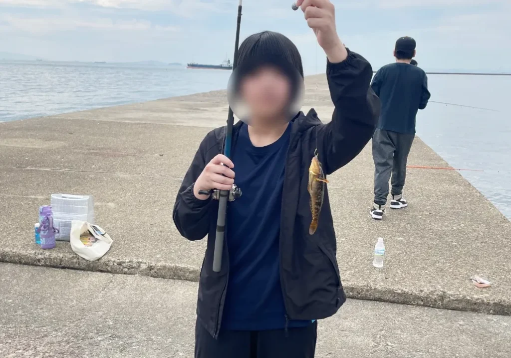 こどもが釣った魚を手にしている