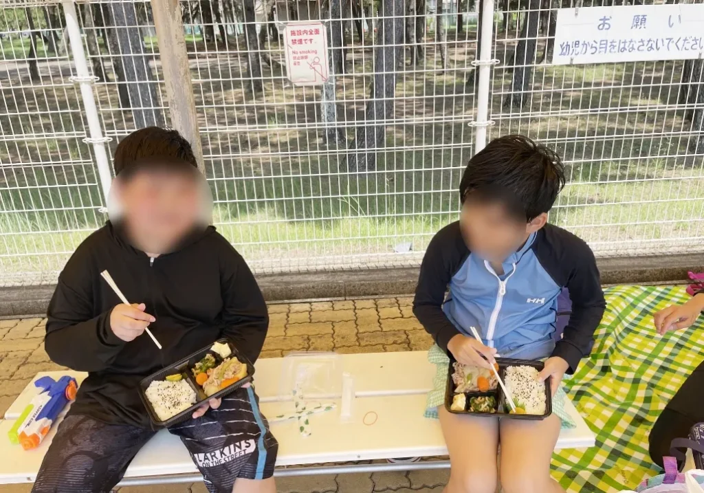 二人のこどもが弁当を食べている